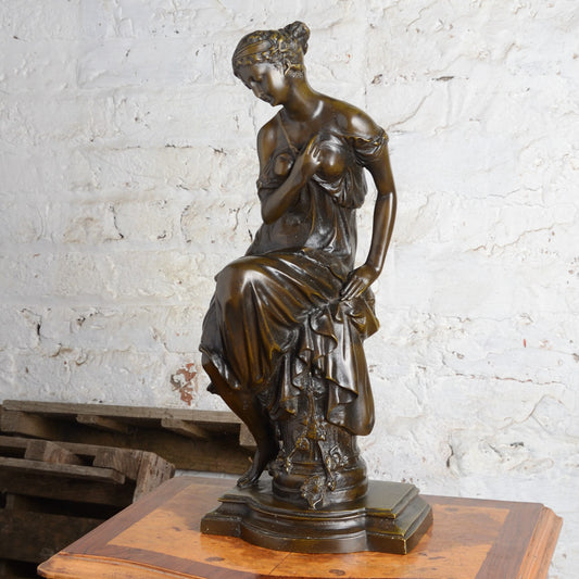 A Bronze figure of a woman seated